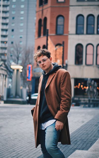 Man_wearing_brown_overcoat_standing_in_city