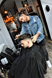 Hairdresser cutting a man's hair in a salon